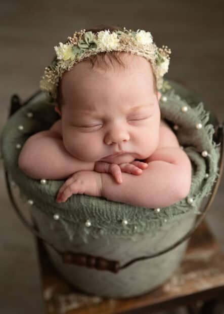 Toledo Newborn Photographer baby in a bucket with hand under chin